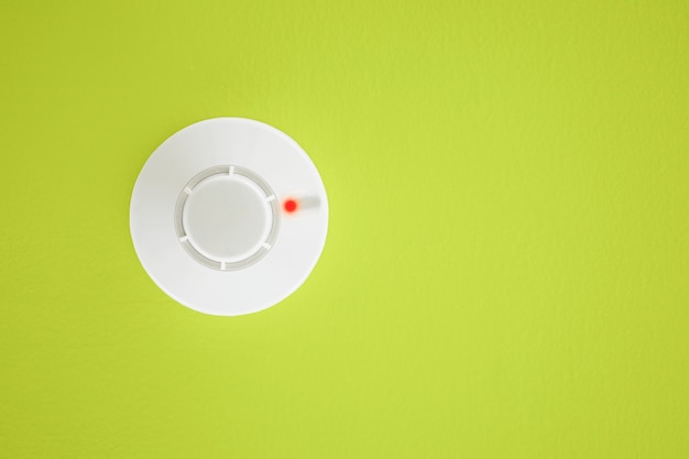 Detector de humo sobre fondo amarillo. Sistema de seguridad.