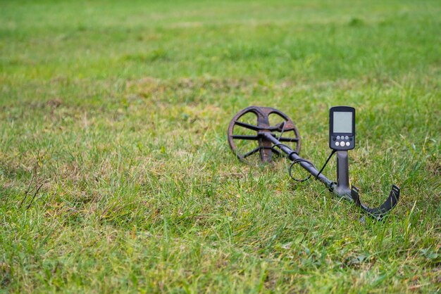 Detector de metales tendido al aire libre sobre la hierba.