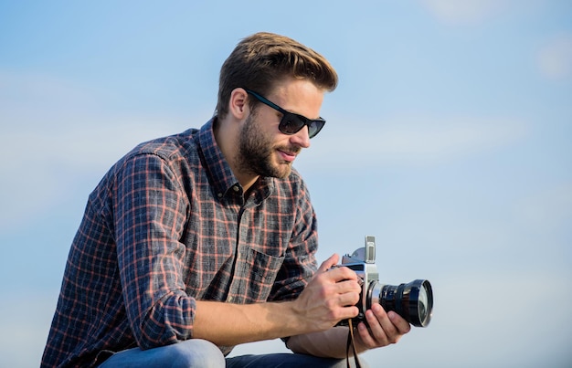 Detén el momento. capturar la aventura. el periodista. hombre macho con cámara. fotógrafo con gafas. viajar con cámara. estilo de moda masculina. buscando a la moda. reportero turístico de hombre sexy.