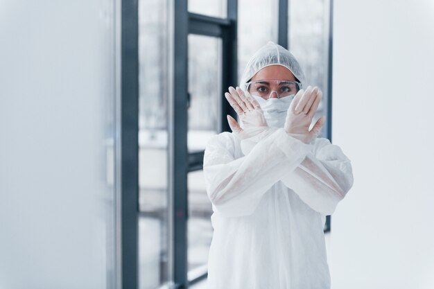 Detén el signo del virus. Retrato de doctora científico en bata de laboratorio, gafas defensivas y máscara