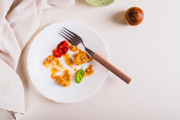 Detener el desperdicio de alimentos Las sobras de comida en un plato después de la cena en la vista de la mesa