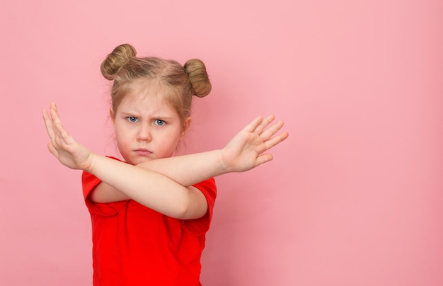 Detener gesto Niña con brazos cruzados fondo rosa con espacio de copia Rechazo de protesta infantil