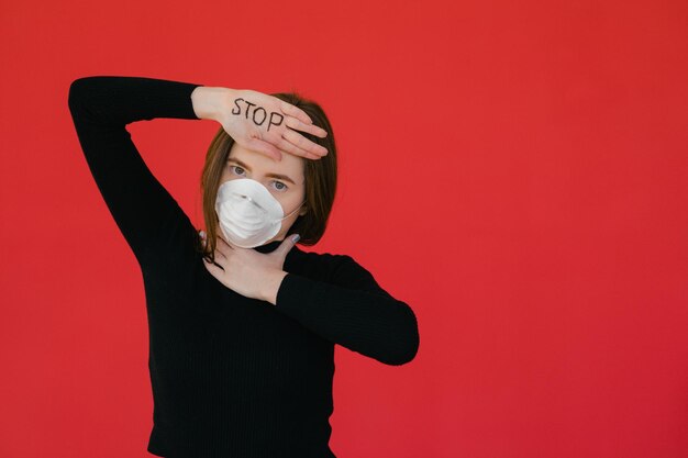 Detenga el virus y las enfermedades epidémicas Mujer sana con máscara protectora médica que muestra el gesto de parada