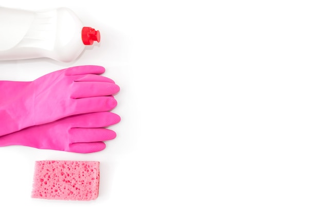 Detergente detergente en una botella con guantes de color rosa y una esponja de cocina sobre un fondo blanco.