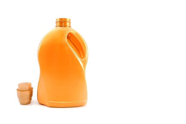 Foto detergente em uma garrafa laranja isolada no branco.