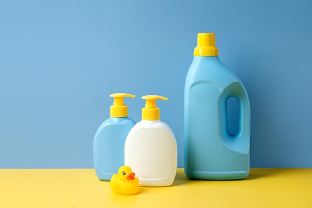 Detergente para roupas infantis e garrafas de sabão sobre fundo azul. Design de embalagens de garrafas em branco de maquete.