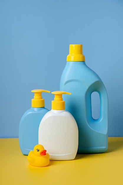 Detergente para ropa de niños y botellas de jabón sobre fondo azul. Diseño de maquetas de envases de botellas en blanco.