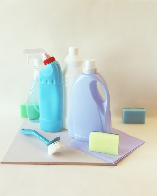 Detergentes líquidos en botellas de plástico, productos de limpieza para el hogar en el fondo claro de la mesa