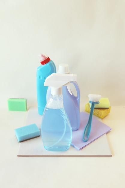 Detergentes líquidos en botellas de plástico, productos de limpieza para el hogar en el fondo claro de la mesa