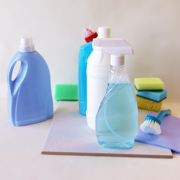 Detergentes líquidos en botellas de plástico productos de limpieza para el hogar en el fondo claro de la mesa