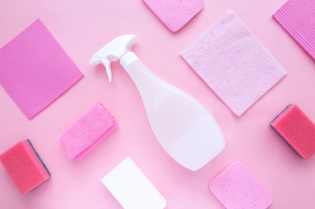 Detergentes y productos de limpieza agente, esponjas, servilletas y guantes de goma, fondo rosa. Vista superior