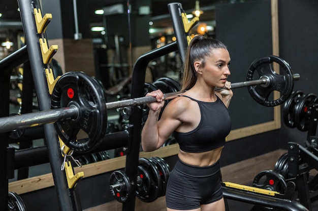 Determinada deportista haciendo ejercicios de levantamiento de pesas con barra