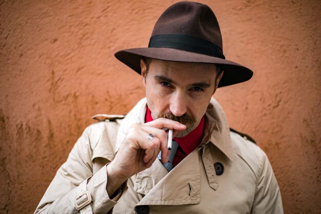 Foto detetive vintage fumando um cigarro em uma favela da cidade