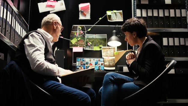 Detetives conversando com colegas on-line em conferência por videochamada, reunindo-se em teletrabalho para discutir sobre o novo relatório de evidências forenses. Assistentes ajudando na captura de suspeitos.