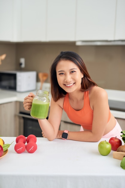 Detox Smoothie Diet Drink. Mulher saudável com corpo em forma, bebendo produtos orgânicos frescos