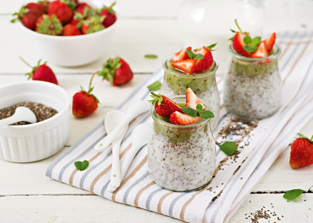 Detox und gesundes superfoods Frühstück im Glas. Chia-Samenpudding der veganen Kokosmilch mit Erdbeeren und Kiwi.