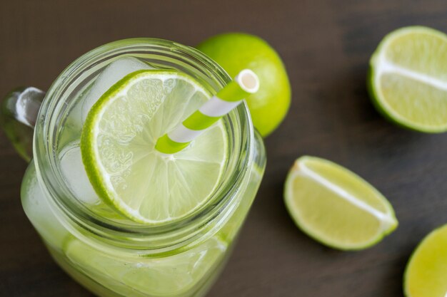 Detoxwasser mit Kalk und Eis auf einem dunklen Hintergrund.