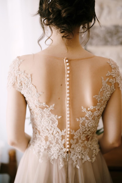 Detrás de la novia con un vestido de encaje con un hermoso peinado