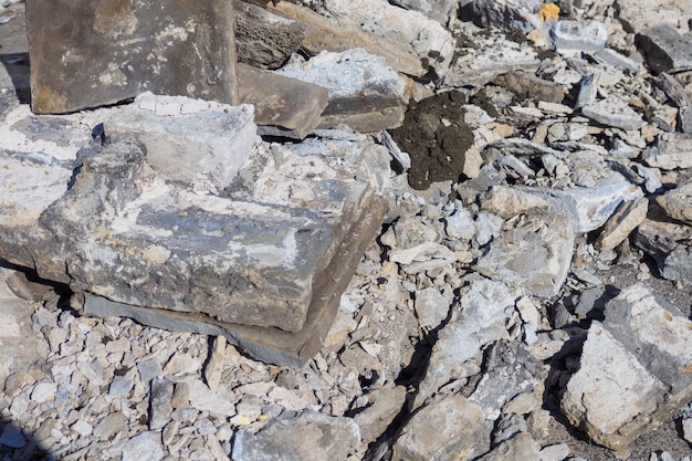 Detritos de construção feitos de pedra quebrada e telhas de concreto estão empilhados na rua no dia de verão