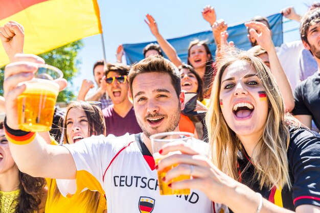 Deutsche Fans feiern im Stadion und trinken Bier