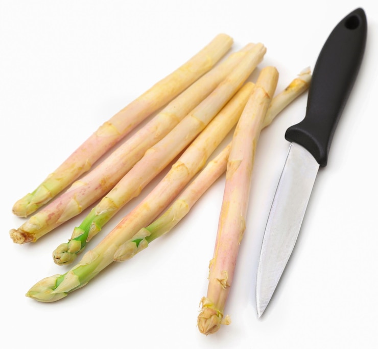 Foto deutscher weißer spargel mit einem messer über weiß