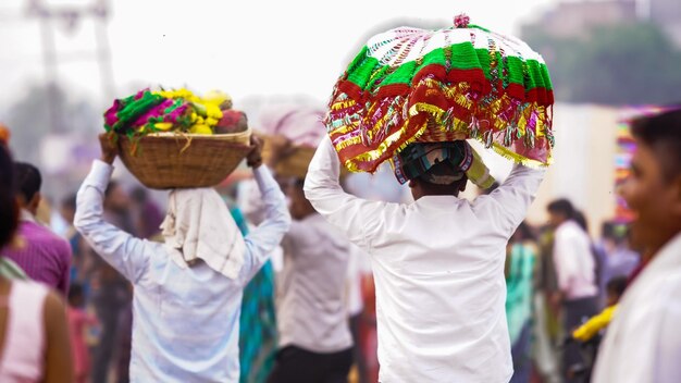 Un devoto lleva pooja o artículos de adoración para Chhath Puja