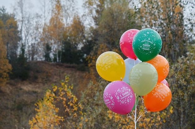 Dez balões infláveis coloridos na floresta de outono Balões inflados com aniversário de hélio