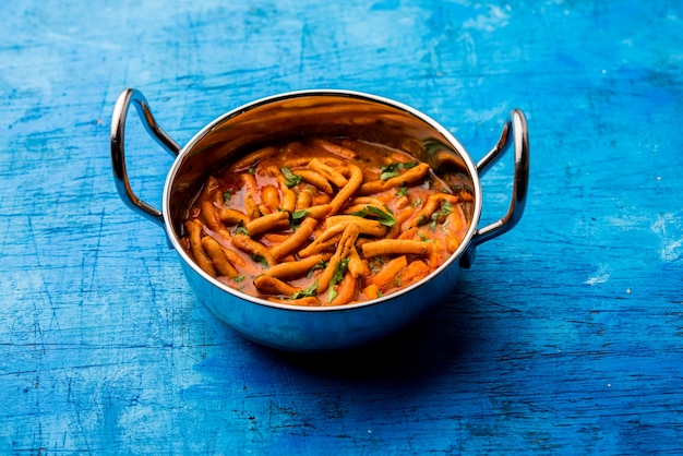 Dhaba-Stil Sev Bhaji, Sabzi, Curry aus Tomatencurry mit Gathiya oder Ganthia Shev, serviert in einer Schüssel oder Karahi, selektiver Fokus