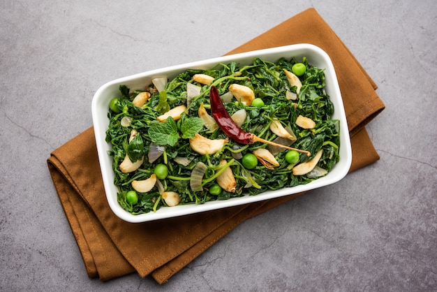 Dhaba Style Lasuni oder Lasooni Methi Fry Sabzi aus frischen Bockshornkleeblättern, Zwiebeln und Knoblauch gemischt mit indischen Gewürzen, serviert in einer Schüssel