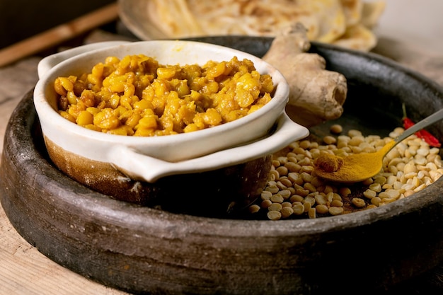 Dhal vegano con pan roti Comida tradicional india de guisantes amarillos dal con pan plano roti servido con limón en un tazón de cerámica sobre una mesa de madera antigua Cerrar
