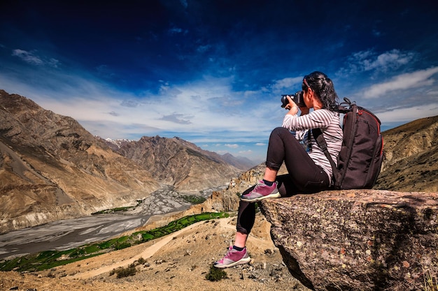 Dhankar gompa. vale de spiti, himachal pradesh, índia. turista de fotógrafo de natureza com câmera dispara em pé no topo da montanha.