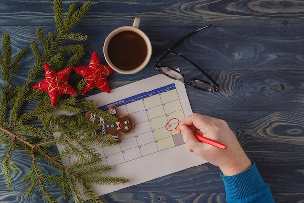 Día 25 del mes, calendario en el fondo del lugar de trabajo con la taza de café de la mañana. Concepto de año nuevo. Espacio vacío para texto