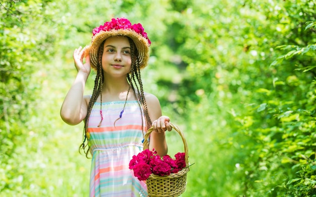 Dia alegre Penteado da natureza dia das mães feliz dia das mulheres Retrato de criança pequena com flores amor e beleza menina deslumbrante com buquê flores de rosas criança feliz no chapéu de palha