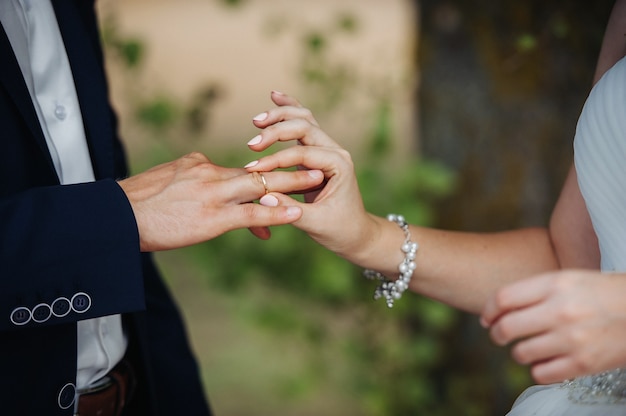 El día de la boda, la novia pone un anillo de compromiso en el dedo del novio.