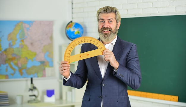 Día del conocimiento Método de enseñanza moderno Cada escuela define las sesiones de examen final Lección de maestro moderno Hombre guapo con barba en la pizarra del aula Estudio y educación Escuela moderna