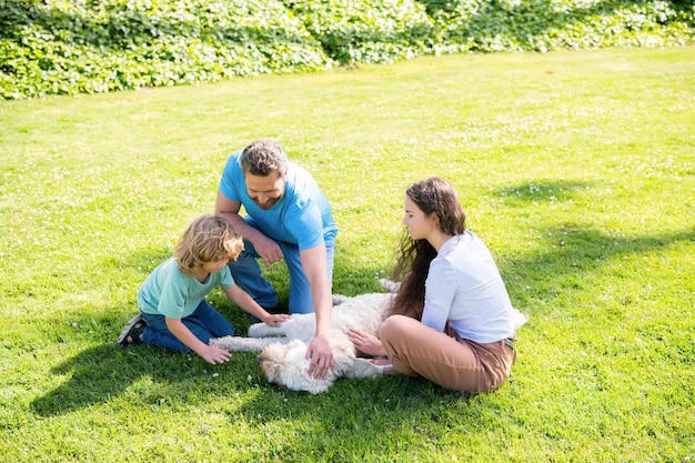 Dia da família amizade pai mãe e filho no parque verde grama amigável família com animal de estimação