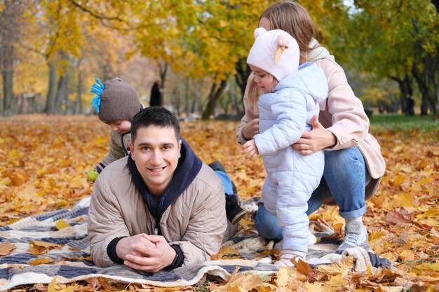 Dia da família no parque outono Mãe e pai com dois filhos passam tempo juntos Foto horizontal