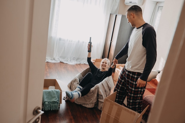 Dia da mudança, nova casa, dia dos namorados, desempacotando caixas, casal conceito de recém-casados, comemorando a mudança para