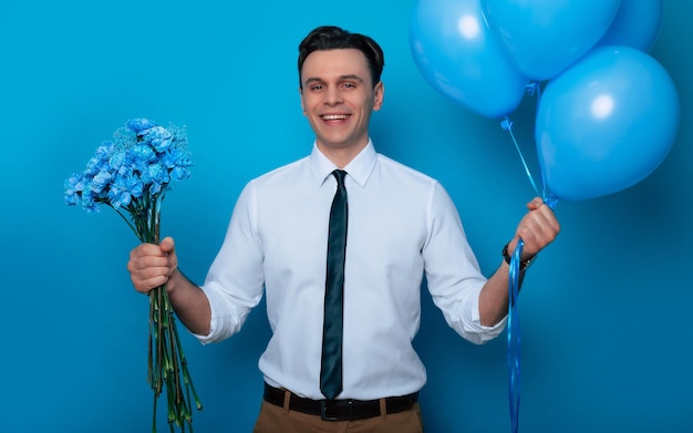Dia da Mulher Dia dos Namorados Feriados de aniversário presentes Feche o retrato de um cara bonito sorridente de camisa e gravata está posando com balões e buquê de flores para sua amada mulher