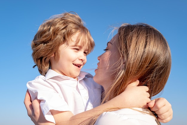 Dia das Mães. Filho de criança abraça a mãe. Mãe e filho sorrindo e se abraçando. Férias em família e união.