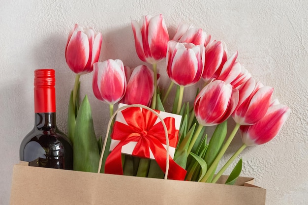Dia das mães ou dia das mulheres felicitações de casamento de aniversário tulipas de primavera com uma caixa de presente