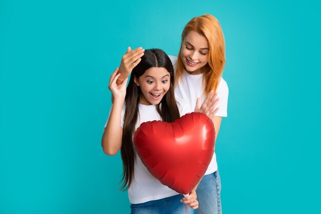 Dia das mães Sorrindo mãe e filha segurando balão de coração de amor no fundo azul Mães felizes