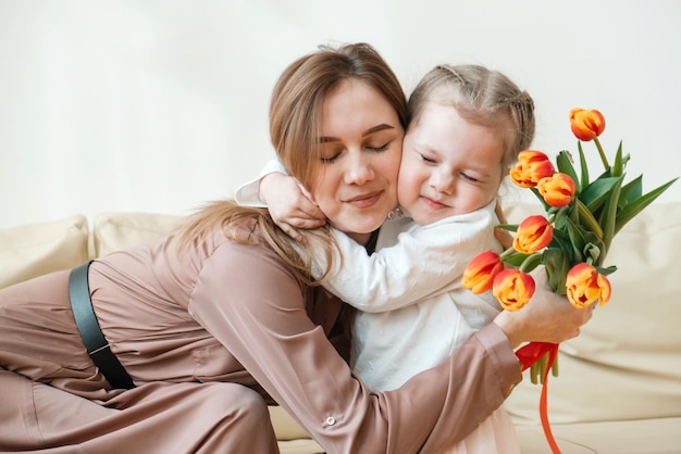 Dia das mães Uma filhinha parabeniza a mãe no feriado e dá tulipas em casa