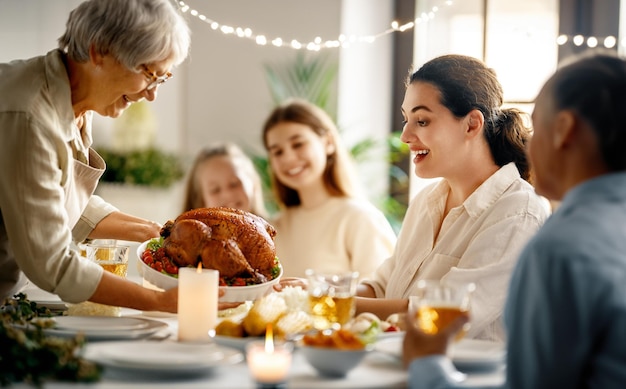 Dia de Ação de Graças Festa de Outono Família feliz sentada à mesa e celebrando o feriado