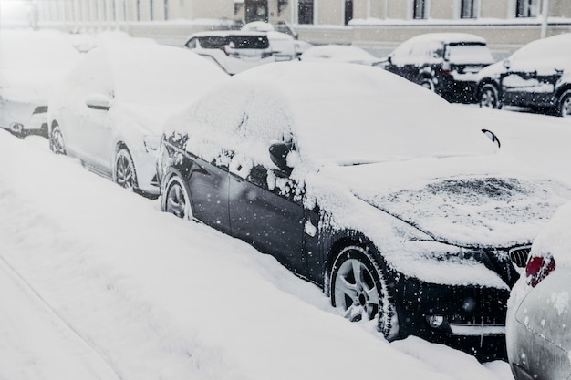 Dia de inverno em ambiente urbano. Os carros estão no estacionamento, coberto de neve branca após uma forte nevasca