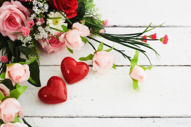 Dia de Valentin romântico com coração vermelho e buquê de flores coloridas na mesa de madeira branca