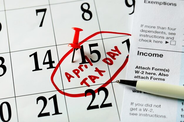 Dia do imposto de abril escrito e fixado em um calendário de perto