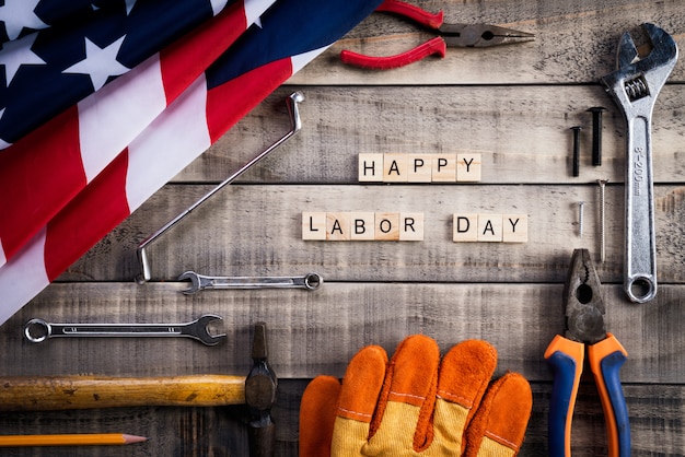 Dia do Trabalhador, EUA bandeira da América com muitas ferramentas úteis em fundo de madeira
