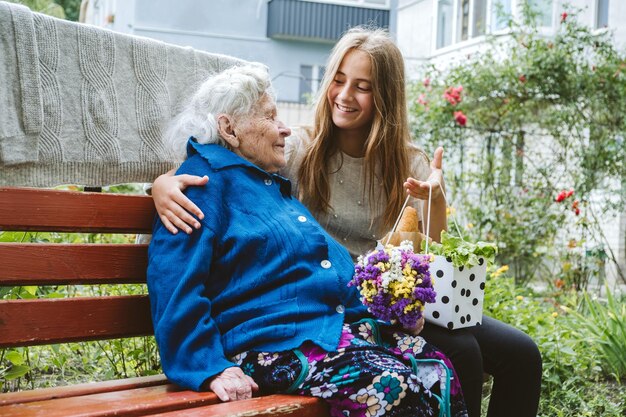 Dia dos avós reunião familiar reunificação avó idosa abraça neta ao ar livre