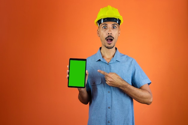 Dia dos engenheiros Homem negro em capacete de segurança e camisa azul isolado Engenheiro segurando celular